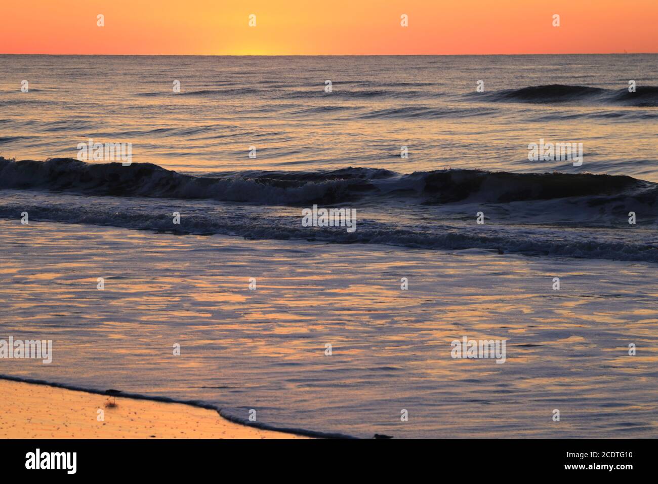 El resplandor naranja del sol que comienza a elevarse sobre el Océano Atlántico en Avalon, Nueva Jersey, EE.UU Foto de stock