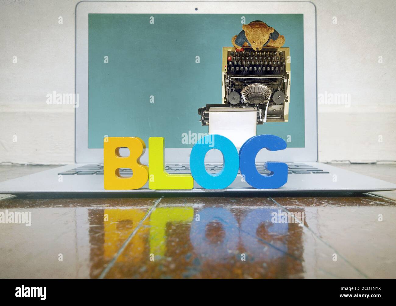 concepto de blogging con letras de madera en un portátil en un suelo de madera Foto de stock