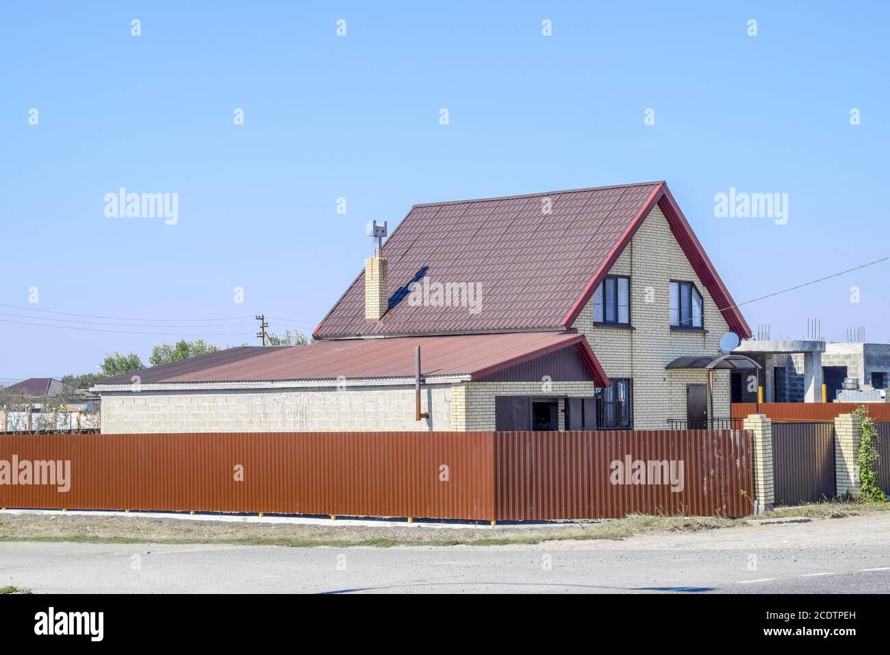 Casa con ventanas de plástico y techo de chapa ondulada. Techado de perfil metálico forma ondulada en la casa con ventanas de plástico Foto de stock