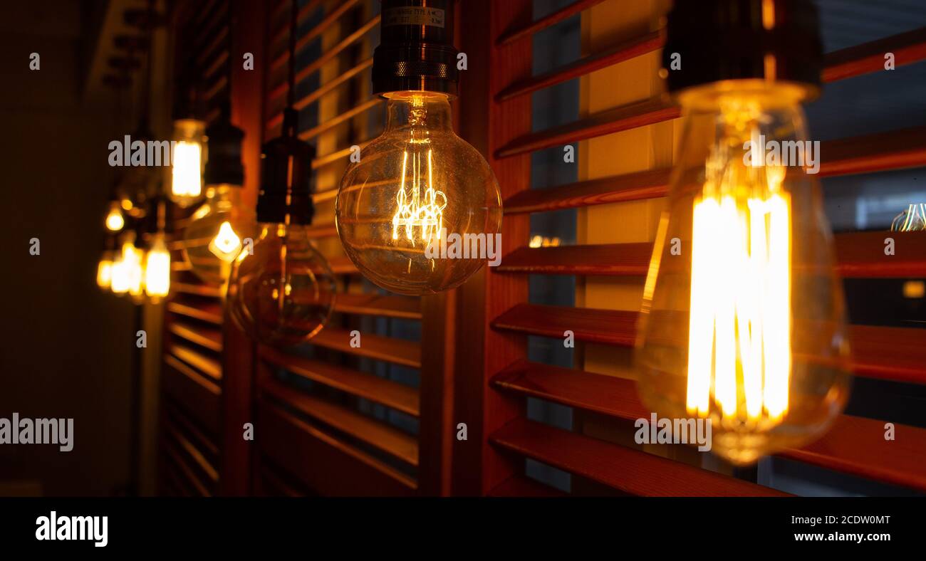Lámparas antiguas doradas de estilo Edison en la oscuridad. Concepto de decoración de iluminación. Bombilla de época. Fondo difuminado de luces retro Foto de stock
