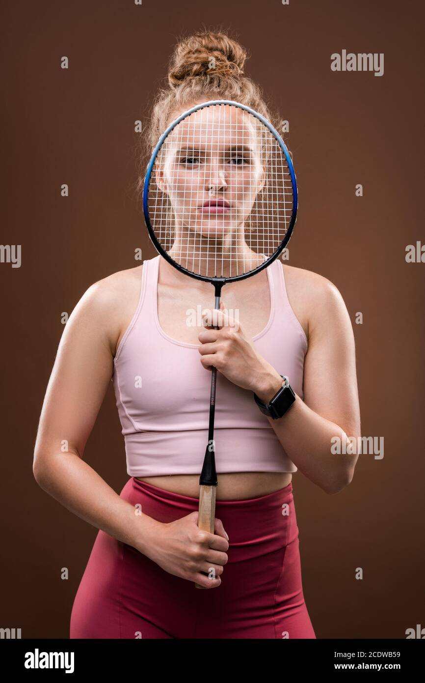 Joven jugadora de tenis sosteniendo la raqueta delante de ella cara aislada Foto de stock