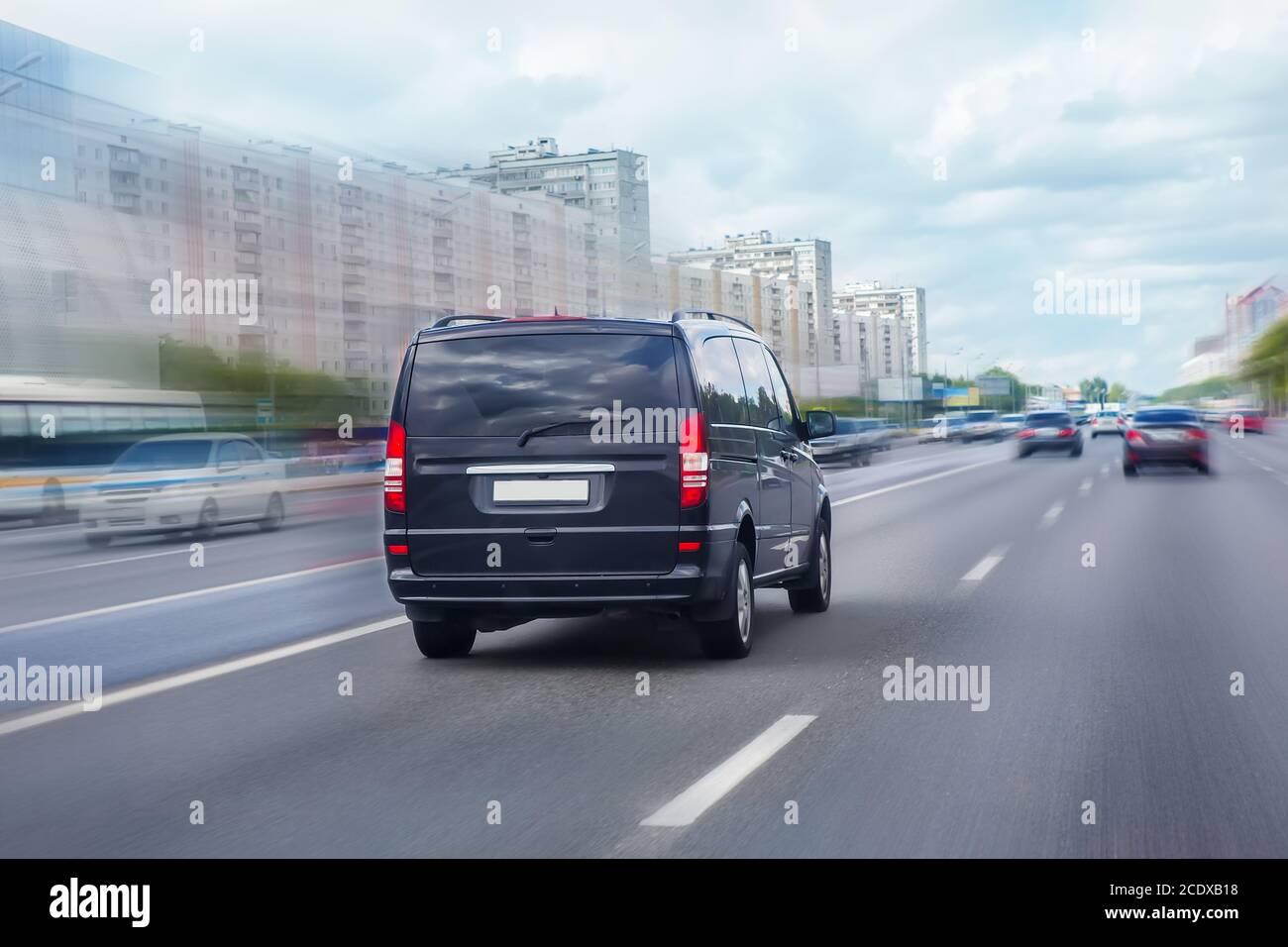 black minivan se está moviendo en la autopista en la ciudad Foto de stock