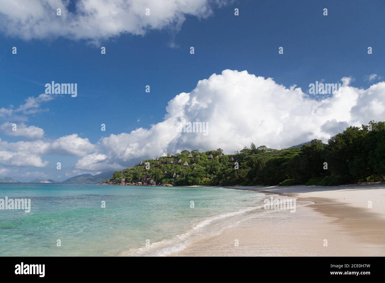 Una playa en las islas Seychelles con arena blanca y piedras Foto de stock