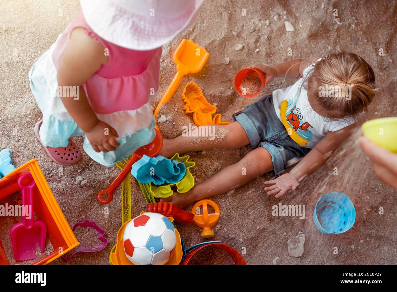 Dos niños pequeños felices jugando con diferentes juguetes coloridos en Sandbox. Con placer vacaciones de verano en la playa. Disfrutar de la infancia. Foto de stock