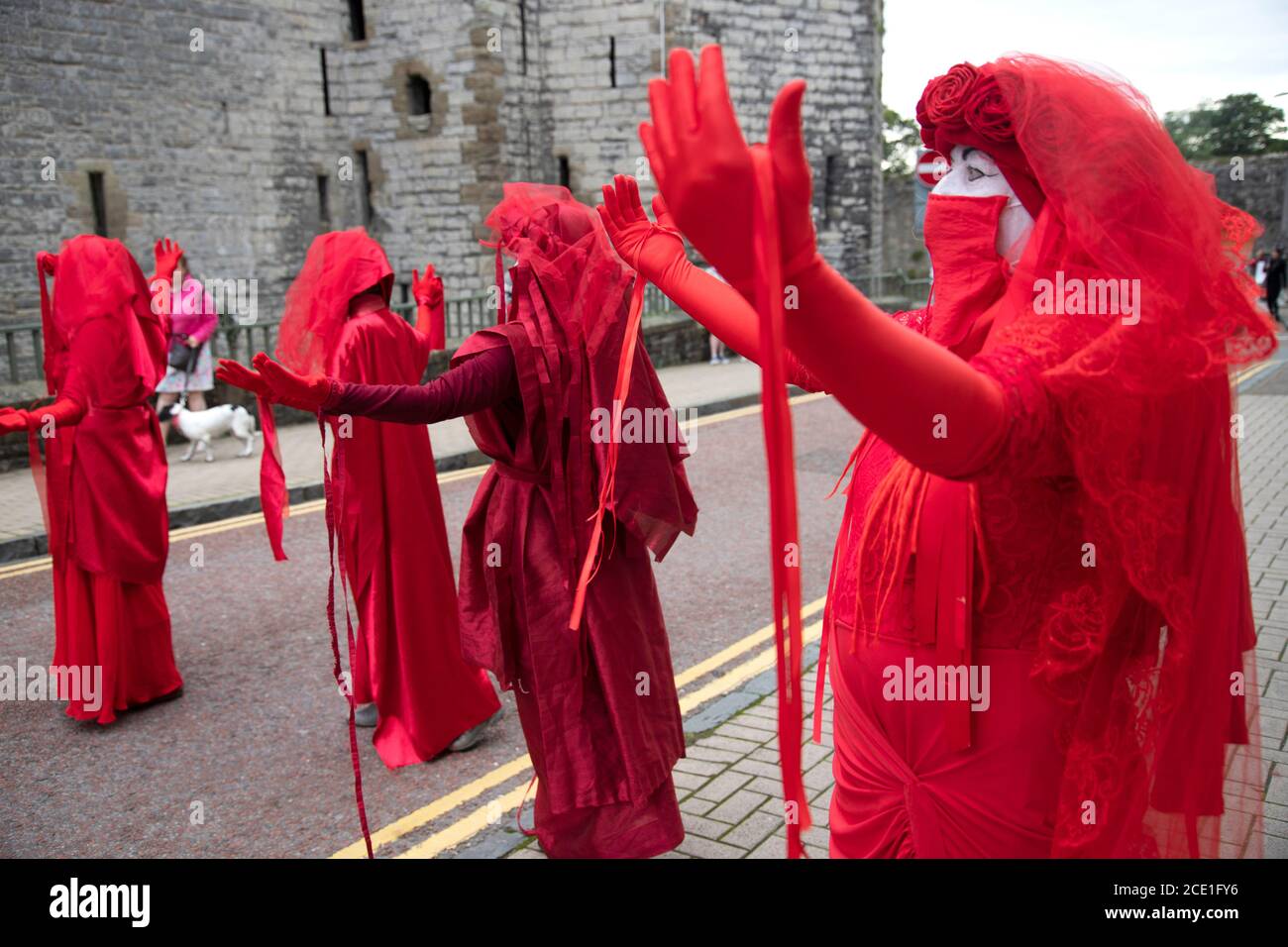 Castillo de Caernarfon, Gales, Reino Unido. 30 de agosto de 2020, extinción los manifestantes de la rebelión y la Brigada Rebelde Roja toman el Castillo de Caernarfon para protestar por el cambio climático y el calentamiento global. Los zapatos de los niños significan que son los niños los que sufrirán en el futuro. Crédito: Denise Laura Baker/Alamy Live News Foto de stock