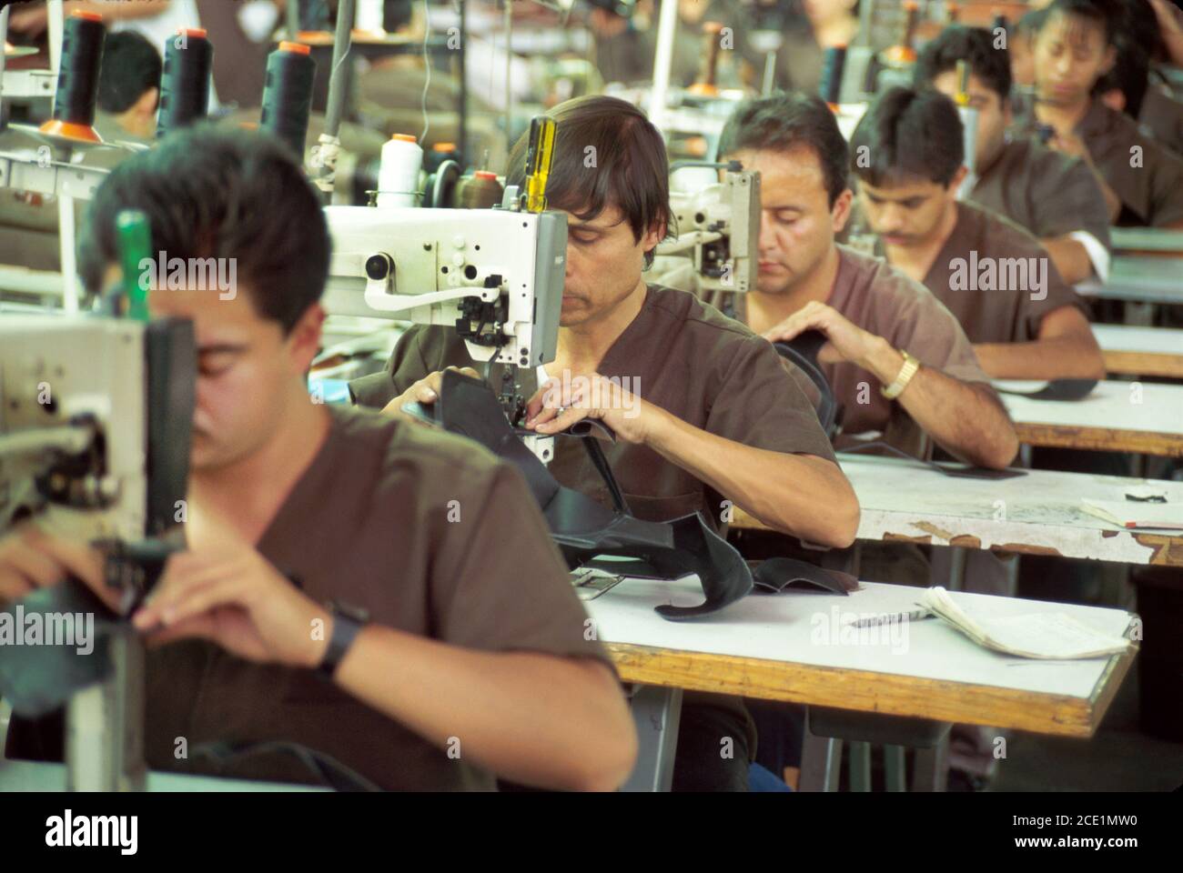 Detalle del trabajador que aplica pegamento a la suela de zapatos en una  línea de producción de la fábrica china de zapatos Fotografía de stock -  Alamy