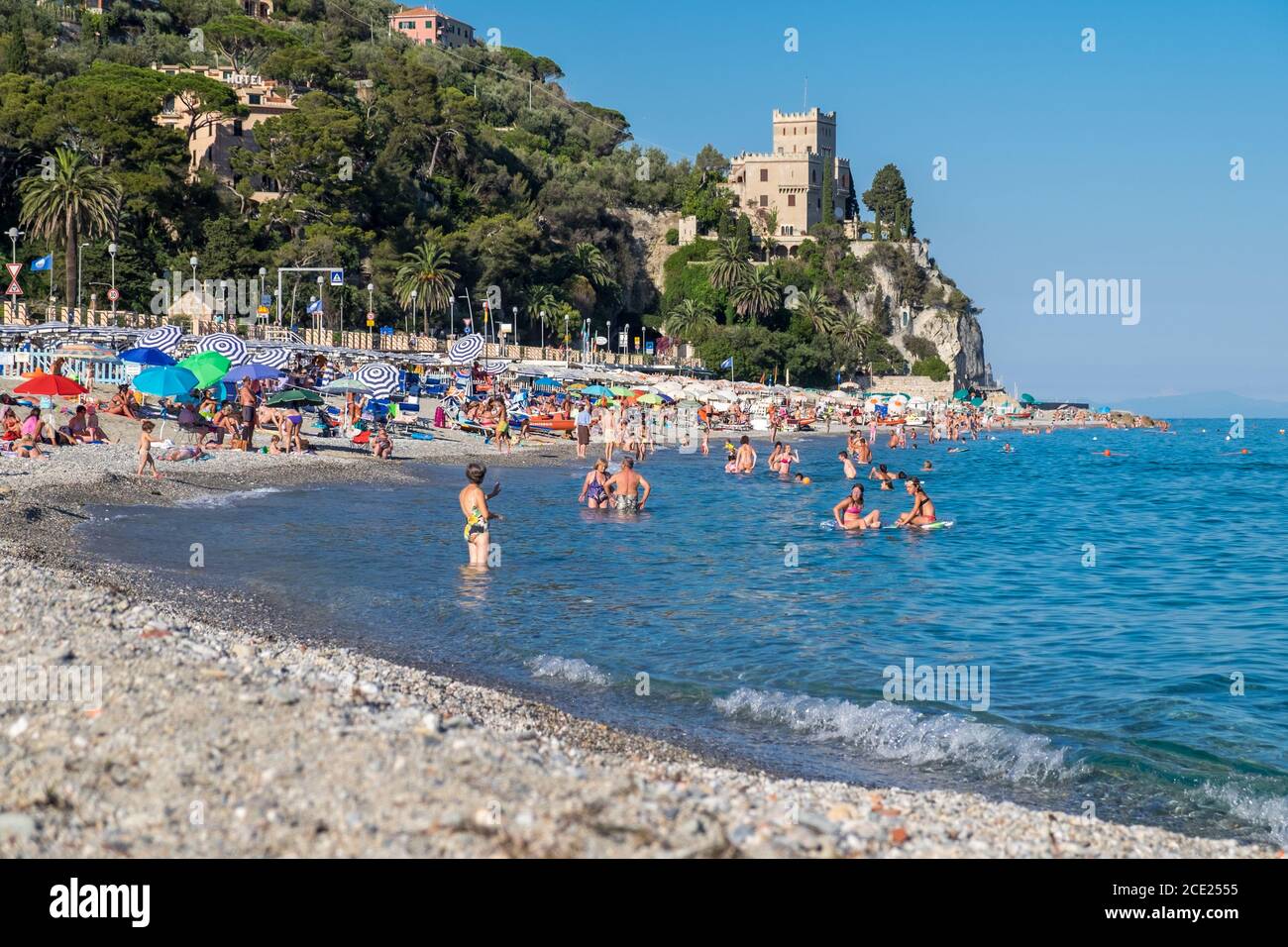 Playa y gente nadando en el mar en Finale Ligure, Liguria, Italia Foto de stock