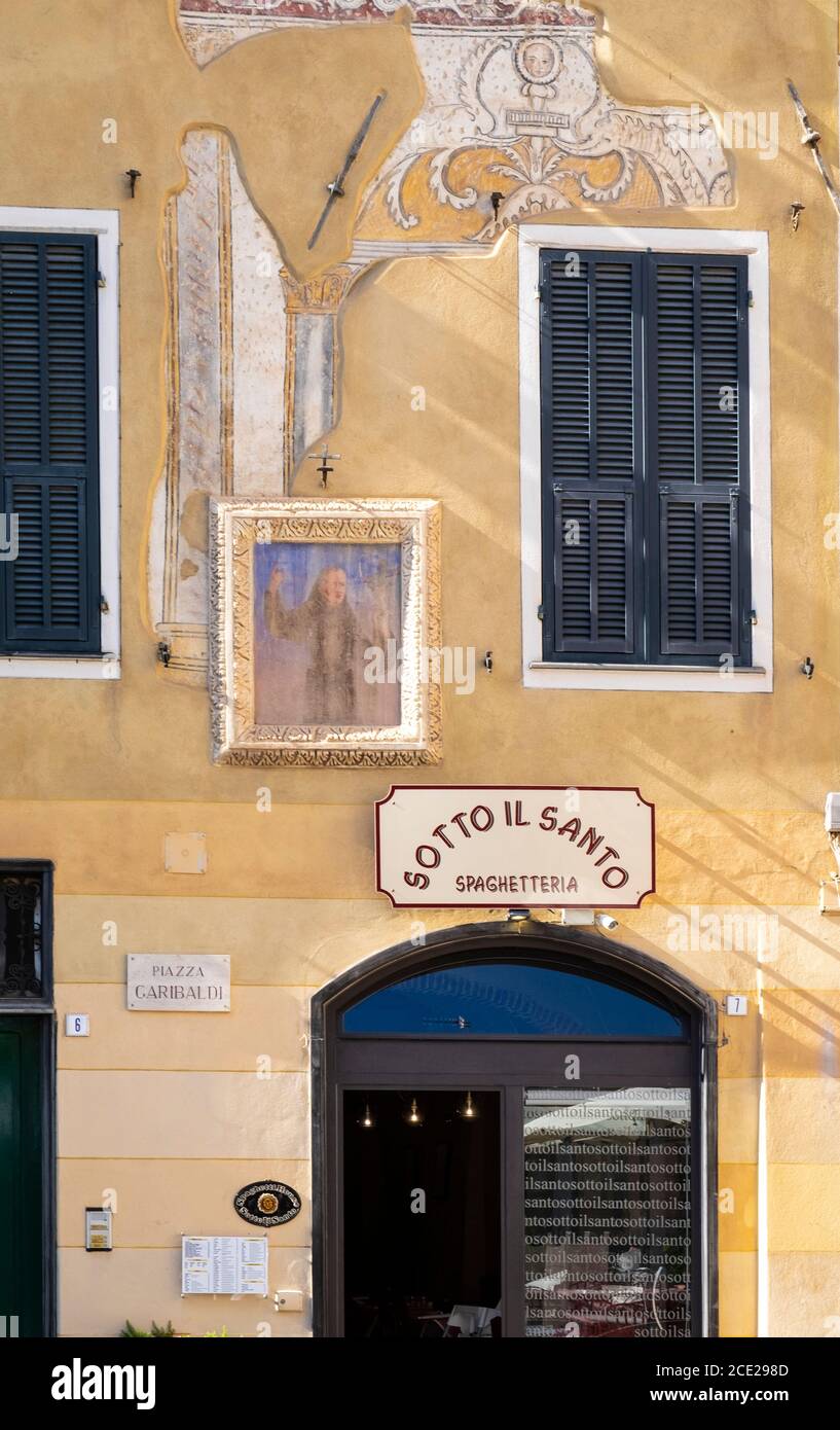 Restaurante Spaghetteria y antiguos edificios de ocre amarillo en el casco antiguo de Finalborgo, Finale Ligure, Liguria, Italia Foto de stock