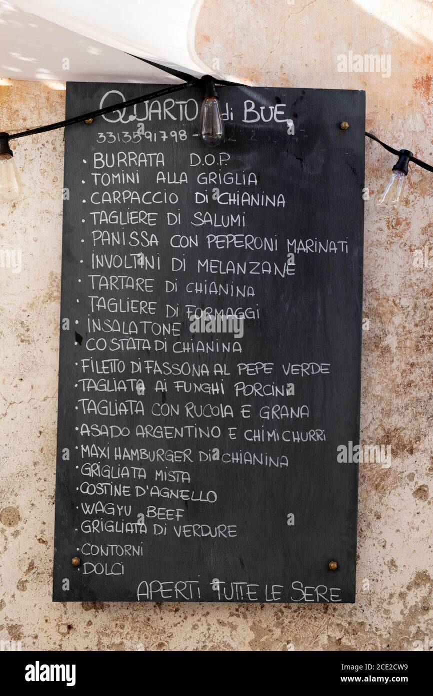 Menú de comida italiana para un restaurante en una pizarra en el casco antiguo de Finalborgo, Finale Ligure, Liguria, Italia Foto de stock