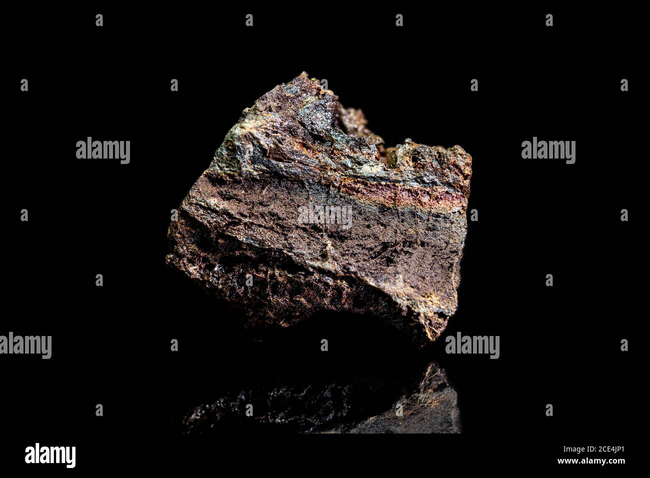 Limonita o mineral de hierro marrón, roca cruda sobre fondo negro, minería y geología, mineralogía Foto de stock