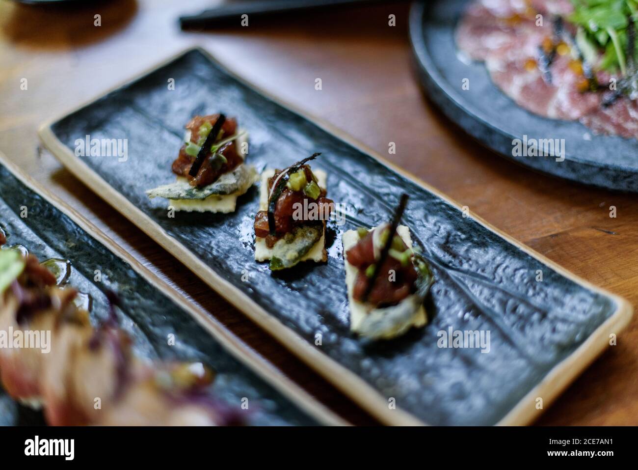 Gran ángulo de delicioso sushi con salmón picado plato sobre mesa en el restaurante Foto de stock