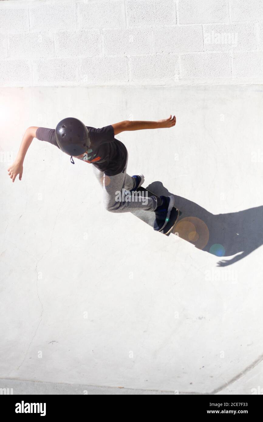 El niño realiza ejercicios y trucos en un cuenco de skate que fluye Foto de stock