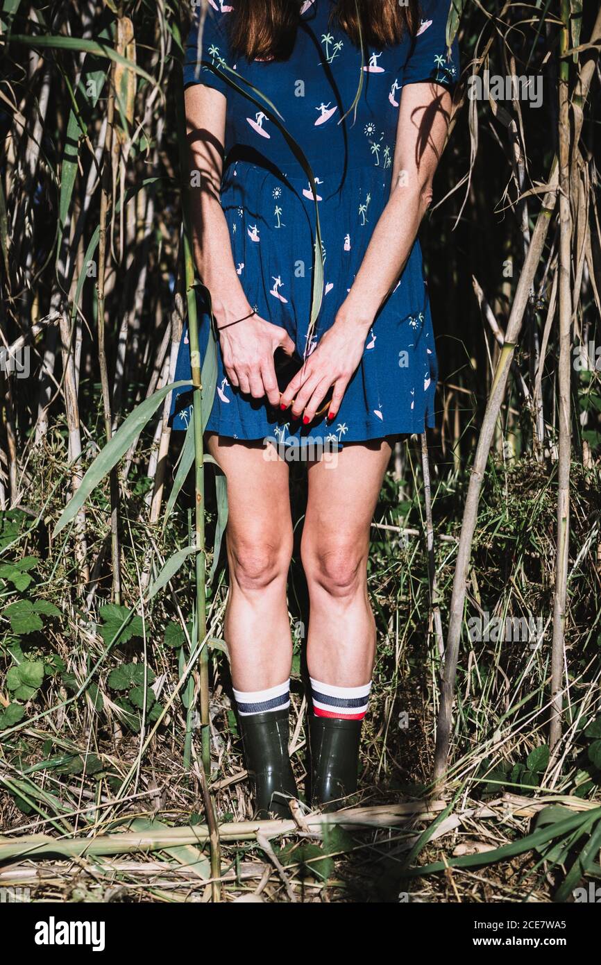 mujer irreconocible en vestido azul y botas de pie en el campo y disfrutar  del sol el día de verano Fotografía de stock - Alamy