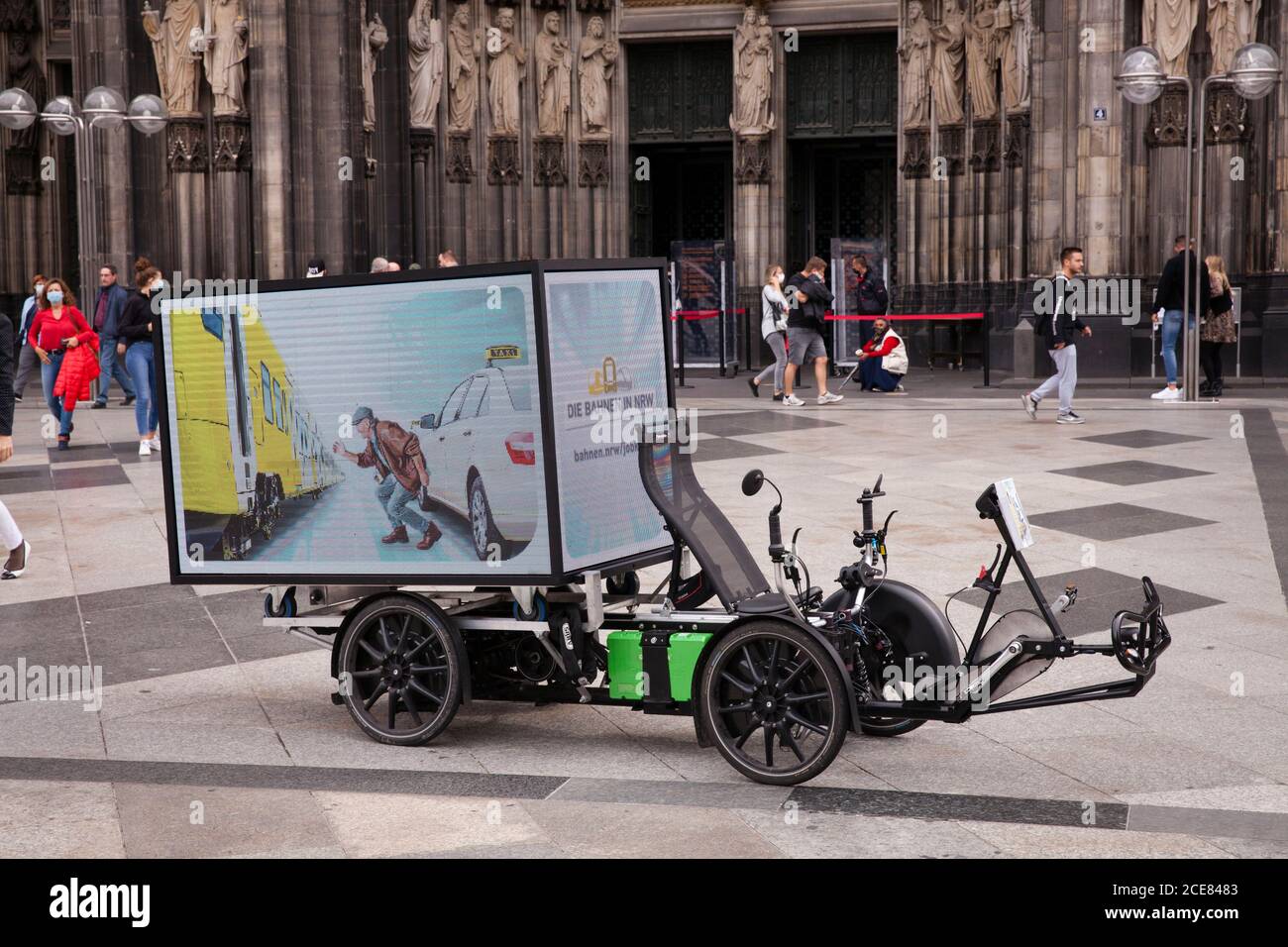 Bicicleta eléctrica (trike) con pantalla digital LED de 360 grados para publicidad móvil al aire libre frente a la catedral, Colonia, Alemania Foto de stock