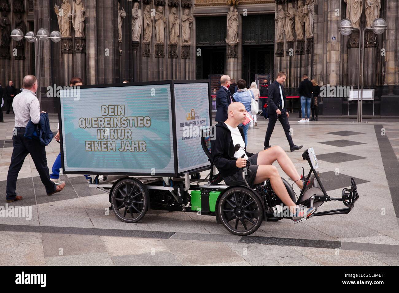 Bicicleta eléctrica (trike) con pantalla digital LED de 360 grados para publicidad móvil al aire libre frente a la catedral, Colonia, Alemania Foto de stock