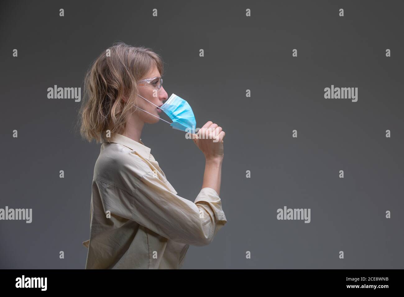 Mujer joven rubia en máscara protectora contra virus. Foto de stock