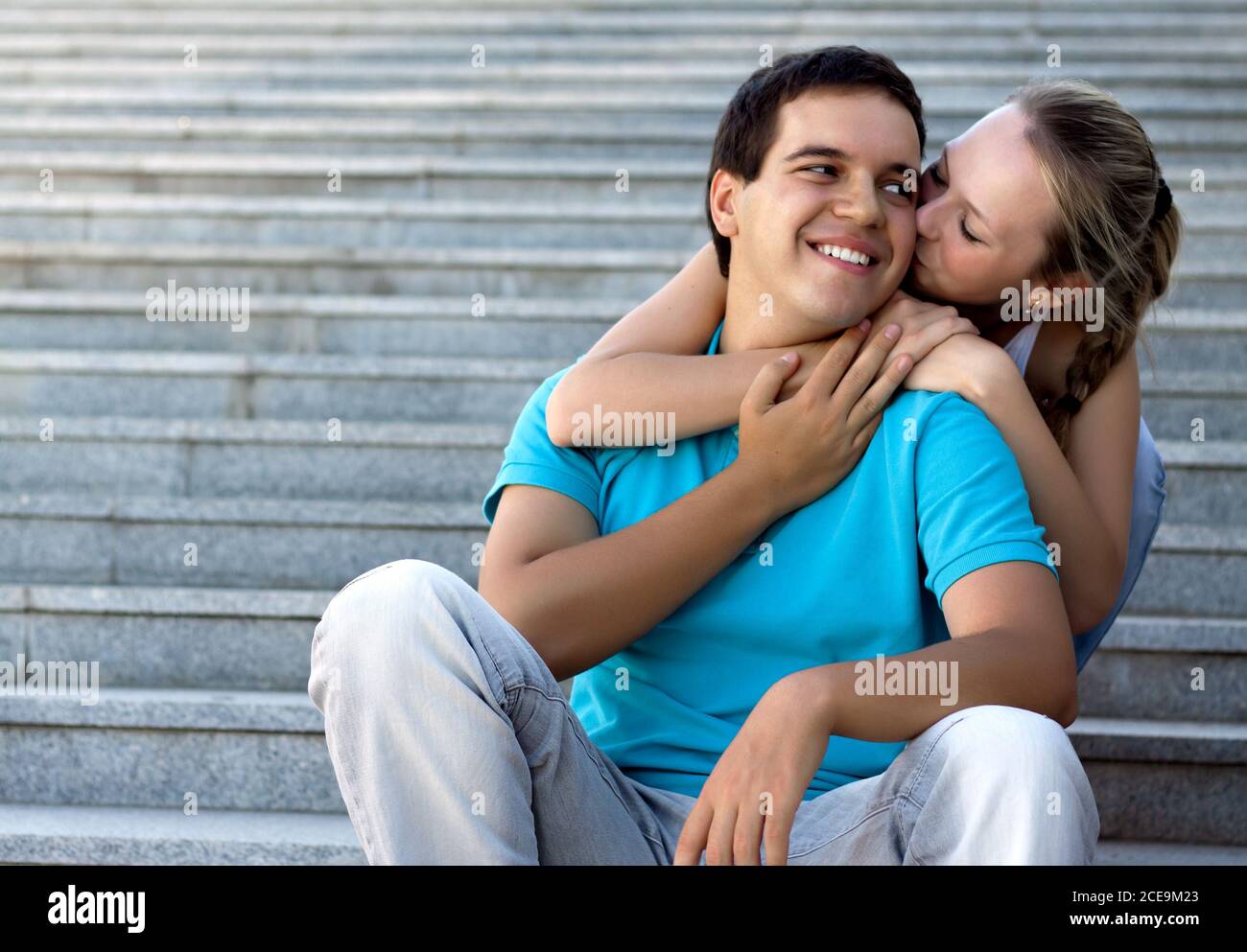 pareja cariñosa sentada en las escaleras y abrazándose Foto de stock
