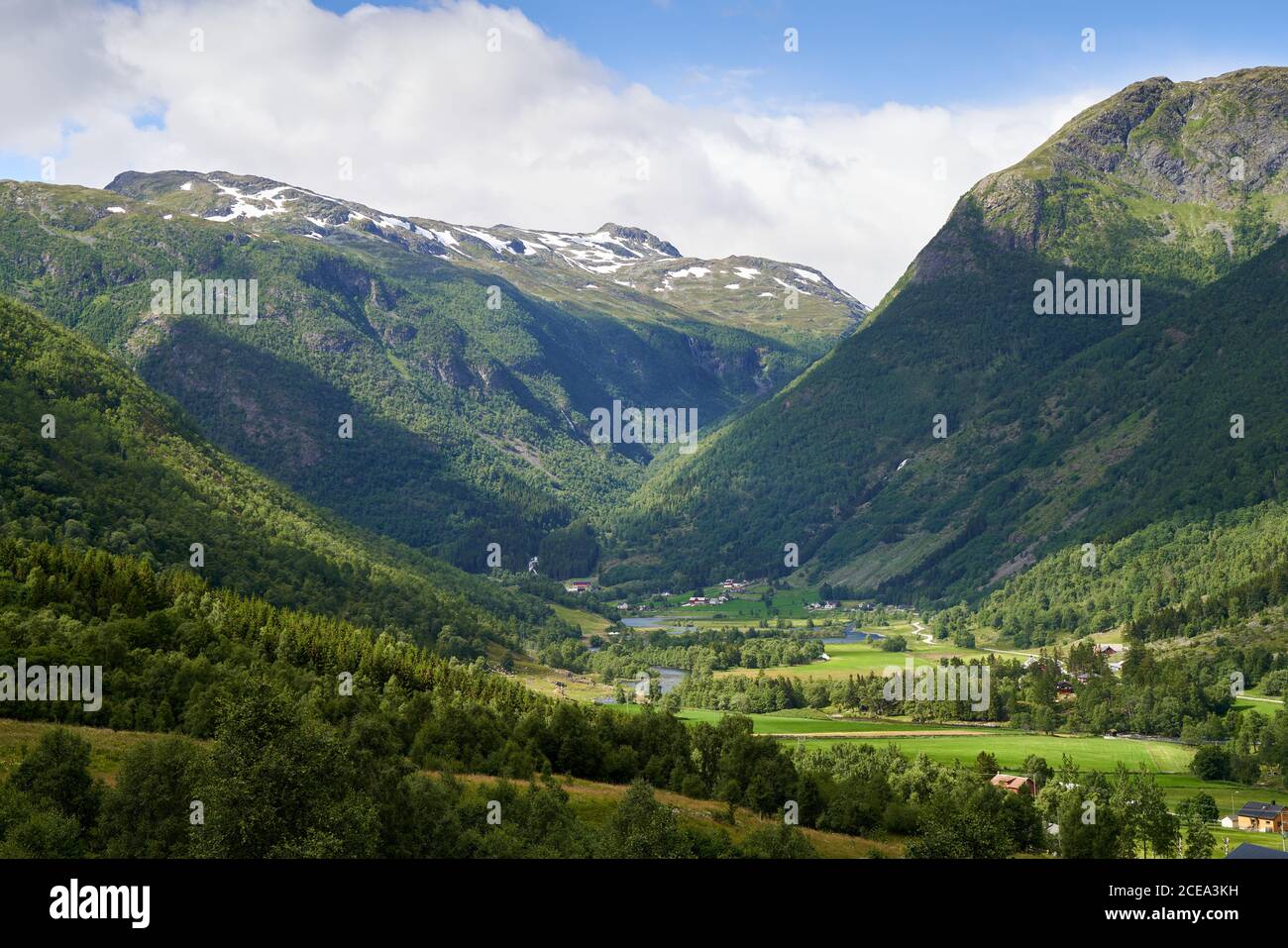 Pequeñas granjas con campos verdes entre las altas montañas noruegas, cerca de Hemsedal Foto de stock