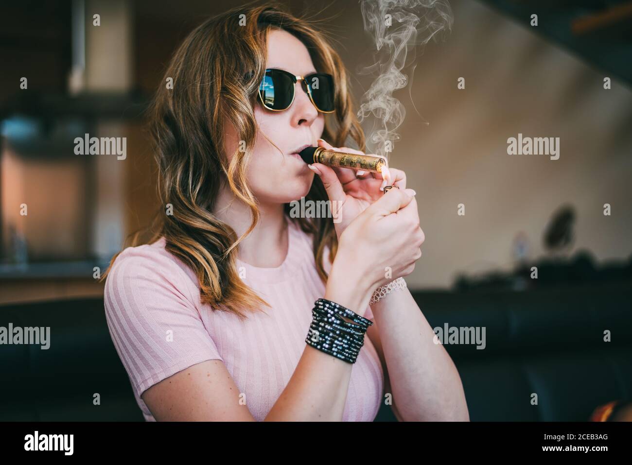 Mujer fumando marihuana en un vaso romo Fotografía de stock - Alamy