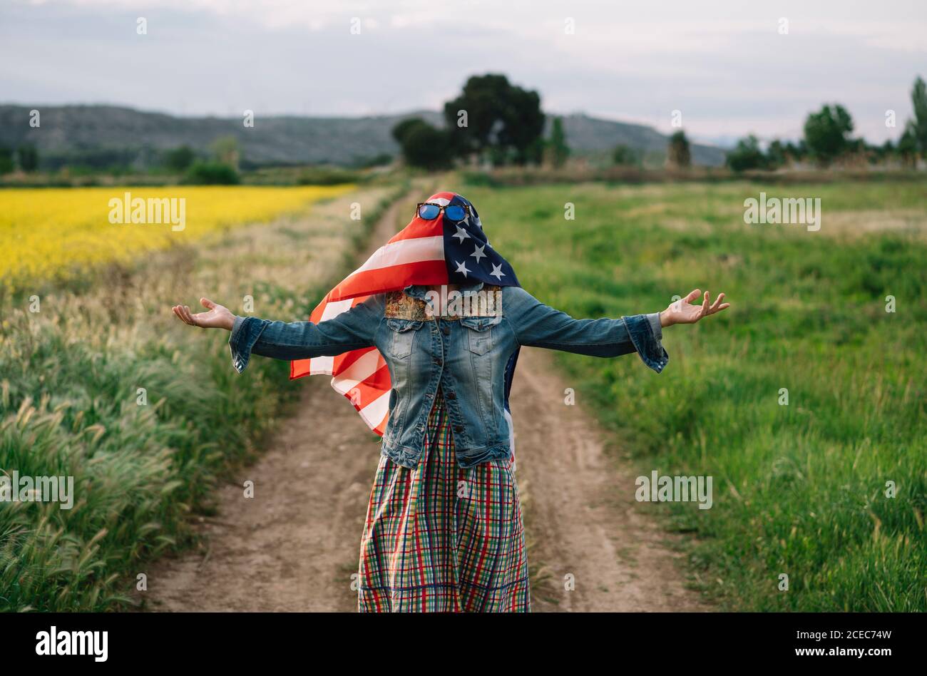Dama con ropa informal permaneciendo en campo amarillo con gafas de sol  Sobre la bandera americana con la luz del sol Fotografía de stock - Alamy