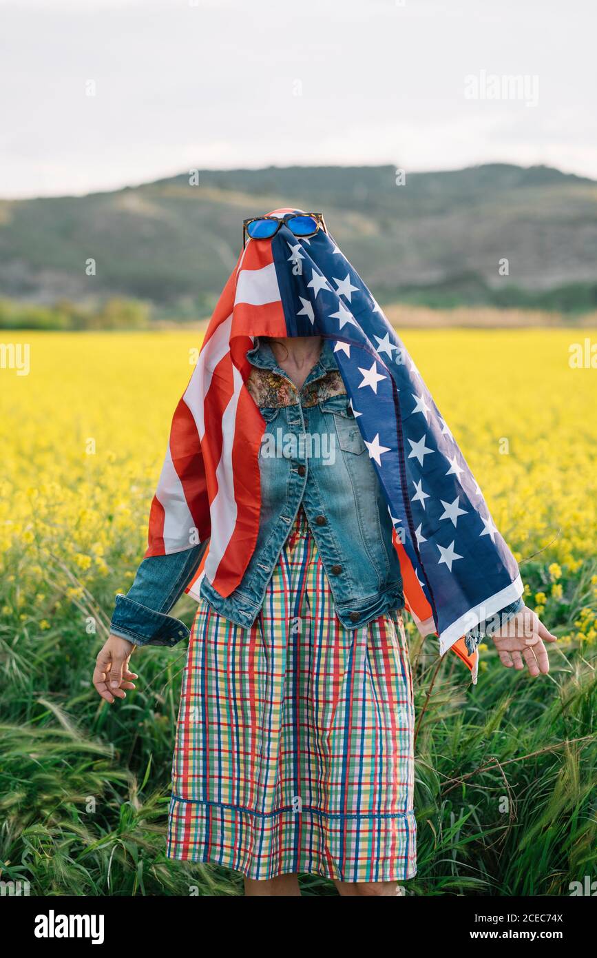 Dama con ropa informal permaneciendo en campo amarillo con gafas de sol  Sobre la bandera americana con la luz del sol Fotografía de stock - Alamy