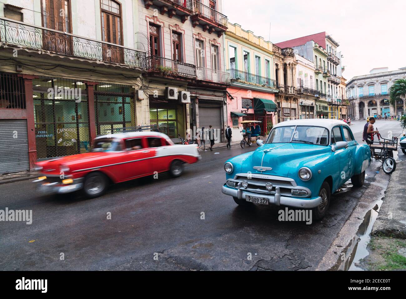 LA HABANA, CUBA - 6 DE NOVIEMBRE de 2018: Automóvil de época en la calle cerca de la construcción entre árboles y macho en día soleado en Cuba Foto de stock