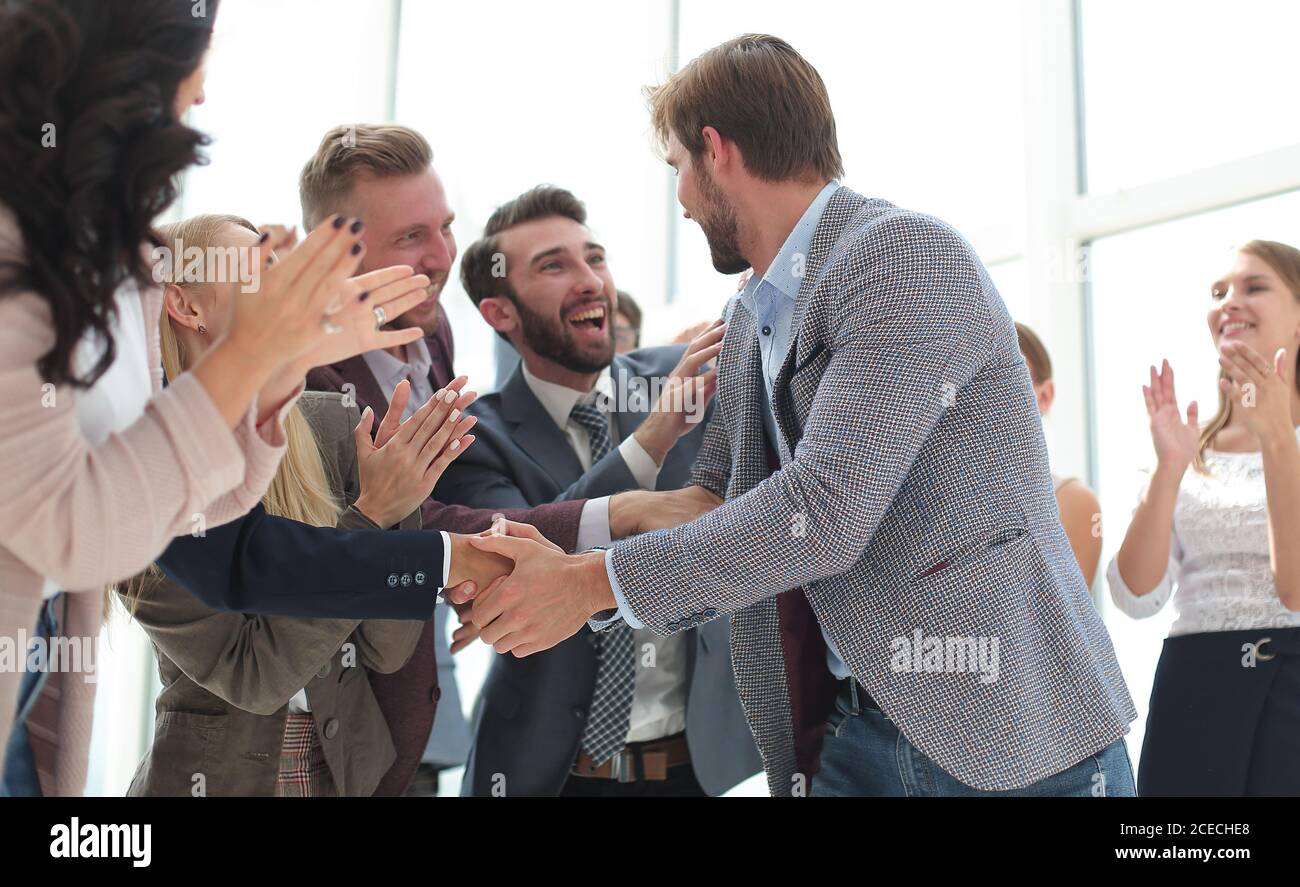 feliz equipo de negocios aplaudiendo al líder de un proyecto exitoso Foto de stock