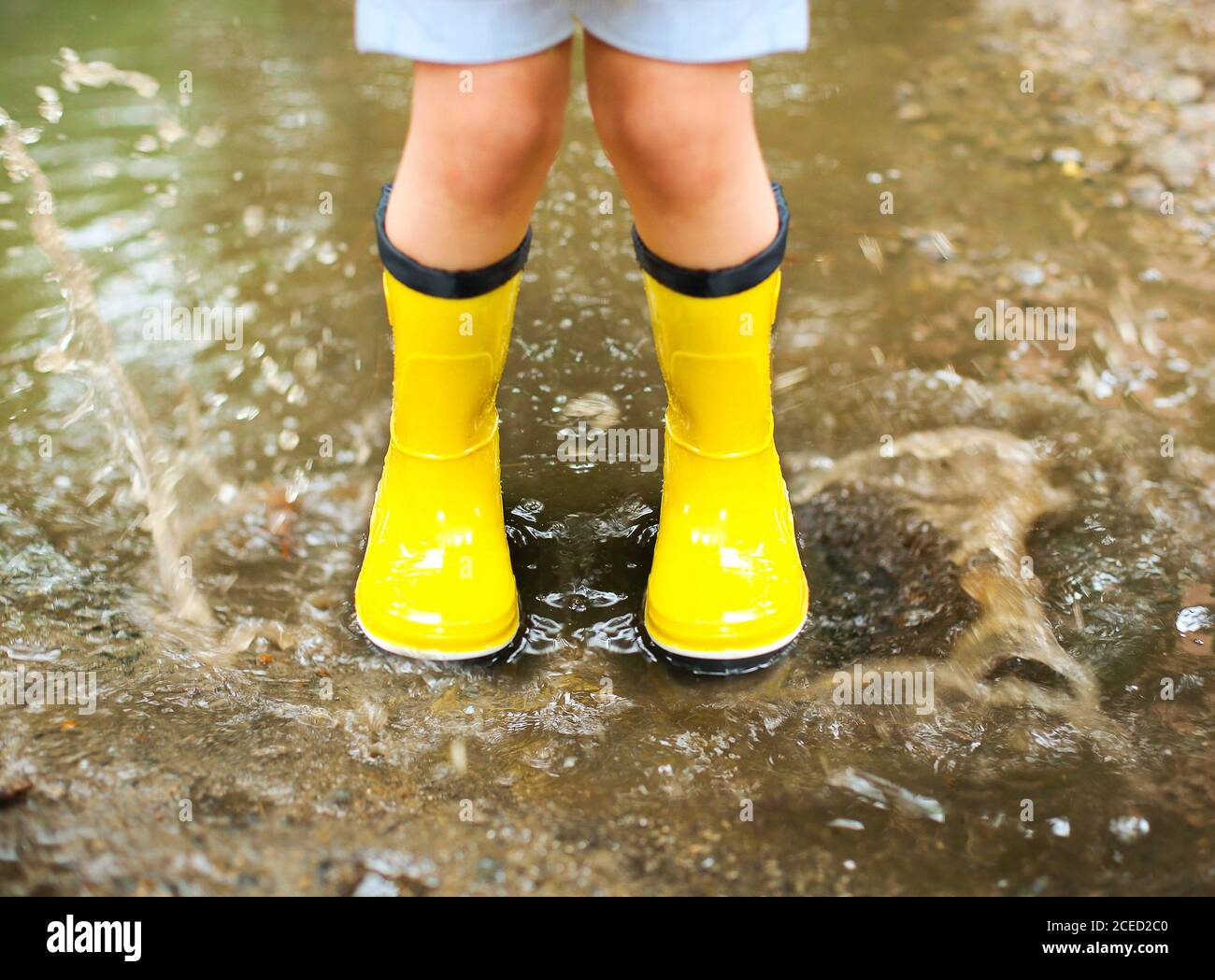 Niña con amarillas y abrigo saltando lluvia día Fotografía de - Alamy