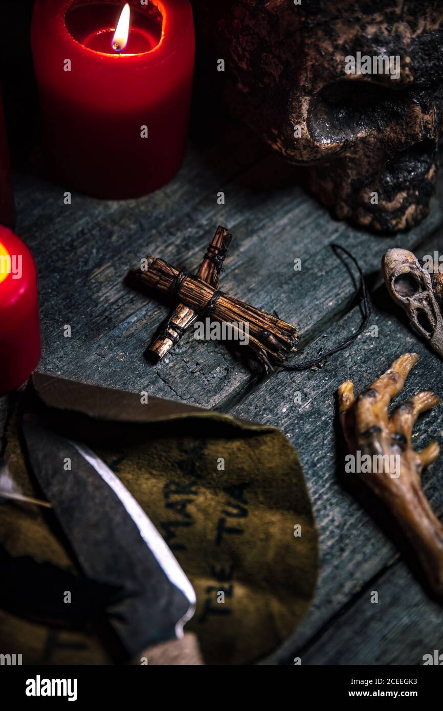 Voodoo o vodun mesa ritual de la muerte, cráneo humano, cuervo´s pies, títere y cuchillo, religión africana y brujería Foto de stock