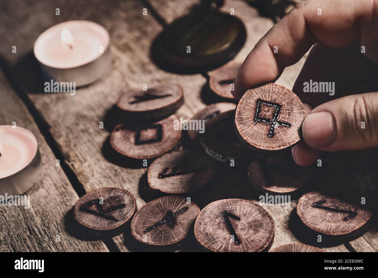 Mano sosteniendo el futhark del runesor de madera, esotérico y la espiritualidad, leyendo y fortuneteller, detalles Foto de stock