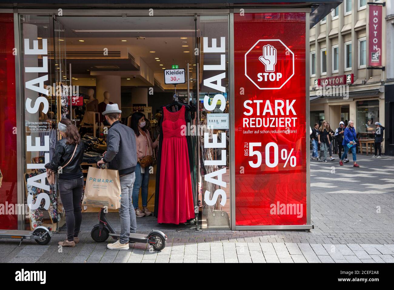 Compre con carteles de venta en la calle comercial Hohe Strasse, Colonia, Alemania. Shop mit Schlussverkauf-Plakaten in der Einkaufsstrasse Hohe Strasse, Koel Foto de stock