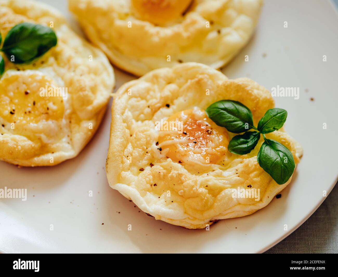 Huevos de nube esponjosos. Comida de moda - horno hornear huevos revueltos  con clara de huevo batida y yema entera en el plato Fotografía de stock -  Alamy