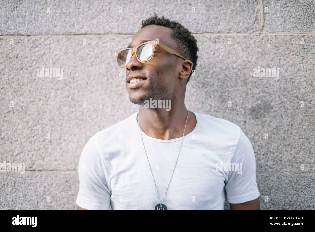 Hombre africano con camisa blanca y gafas de sol posando Fotografía de  stock - Alamy