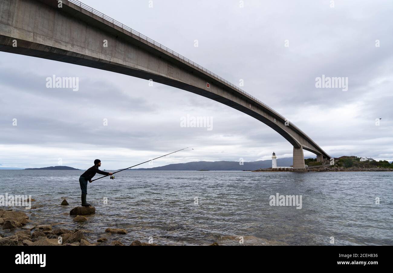 Vista de la pesca de hombre por debajo del puente Skye que une tierra firme con la isla de Skye, Escocia, Reino Unido Foto de stock