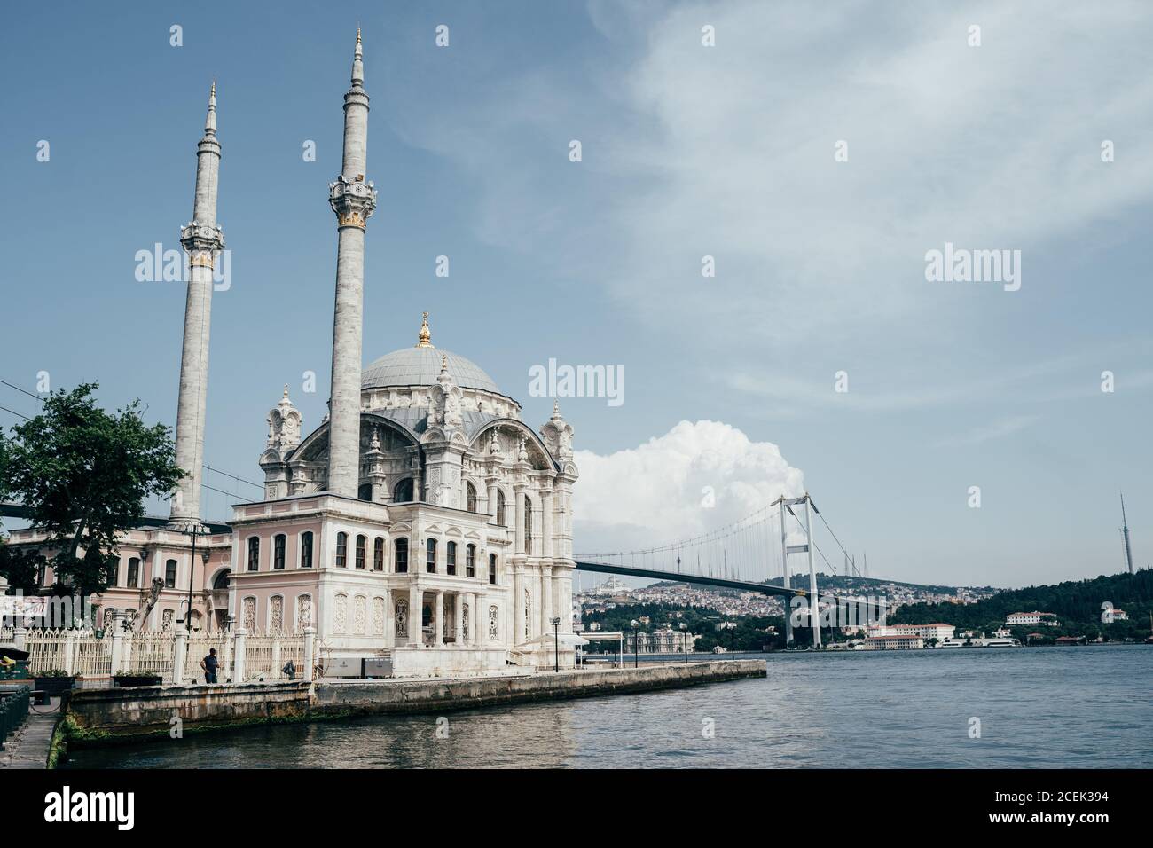 Magnífica vista de la hermosa mezquita situada cerca de aguas tranquilas en un día nublado en Estambul, Turquía Foto de stock