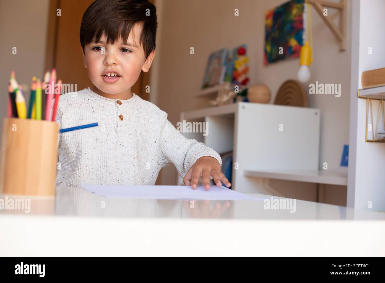 Pequeño niño de preescolar dibujo con lápices de colores. Homeschooling. Comunidad de aprendizaje. Escuela Montessori. Foto de stock