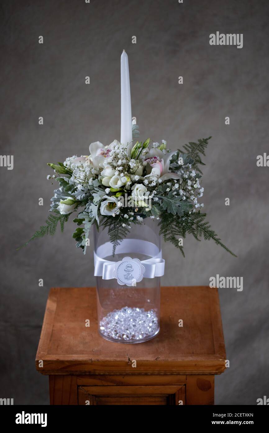 Primera comunión Santa flores ramos. Vela blanca decorada con orquídeas y flores  flores blancas Fotografía de stock - Alamy