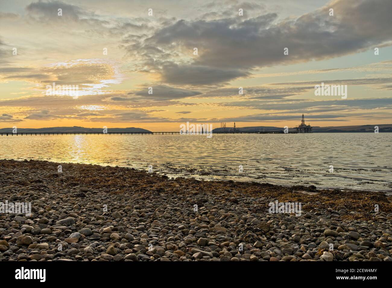 Amanecer sobre plataformas petrolíferas apiladas vistas desde Invergordo en Ross y Cromarty Escocia, Foto de stock