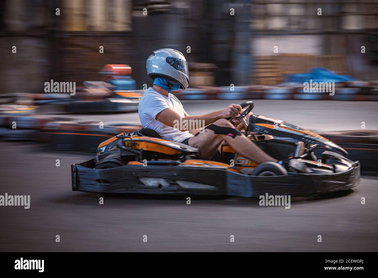 Hombre conduciendo un kart en una pista cubierta Foto de stock