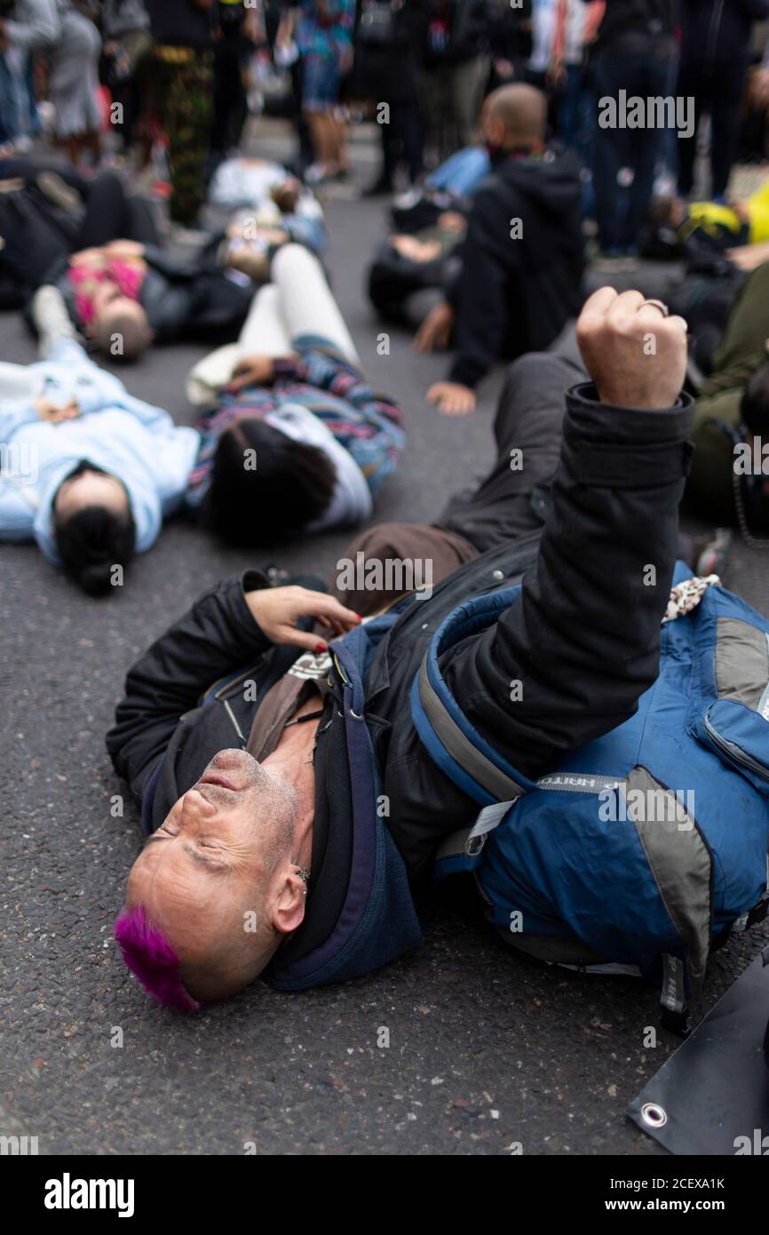 Un hombre se encuentra en el camino con su puño levantado durante la marcha de millones de personas, Londres, 30 de agosto de 2020 Foto de stock