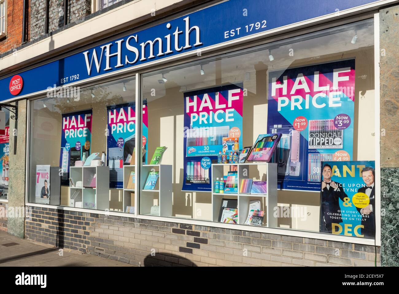 High Street sucursal de WH Smith con anuncios de venta a mitad de precio en las ventanas de la tienda. WH Smith anunció recientemente cierres y despidos posteriores al cierre Foto de stock