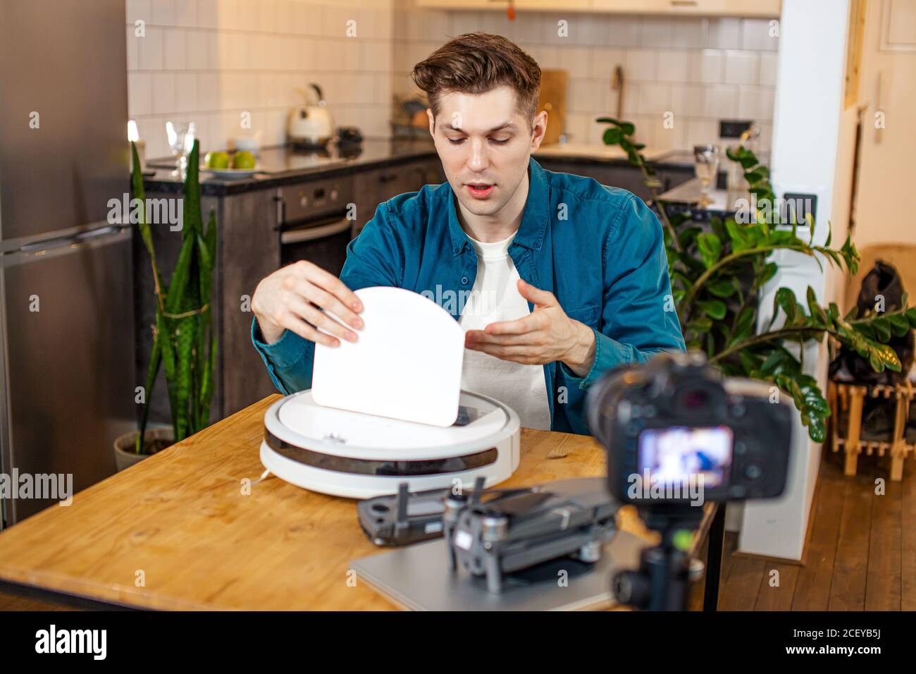joven bloguero caucásico interesado en las nuevas tecnologías modernas, él muestra cómo utilizar un dispositivo particular, quiere ser útil e interesante para la audioenc Foto de stock