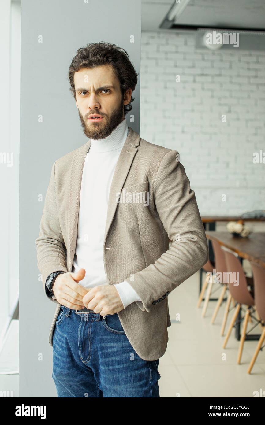 un hombre con barba que se viste con confianza con ropa formal en una  moderna sala de juntas después de una conferencia de negocios con los  socios. el éxito y la gente