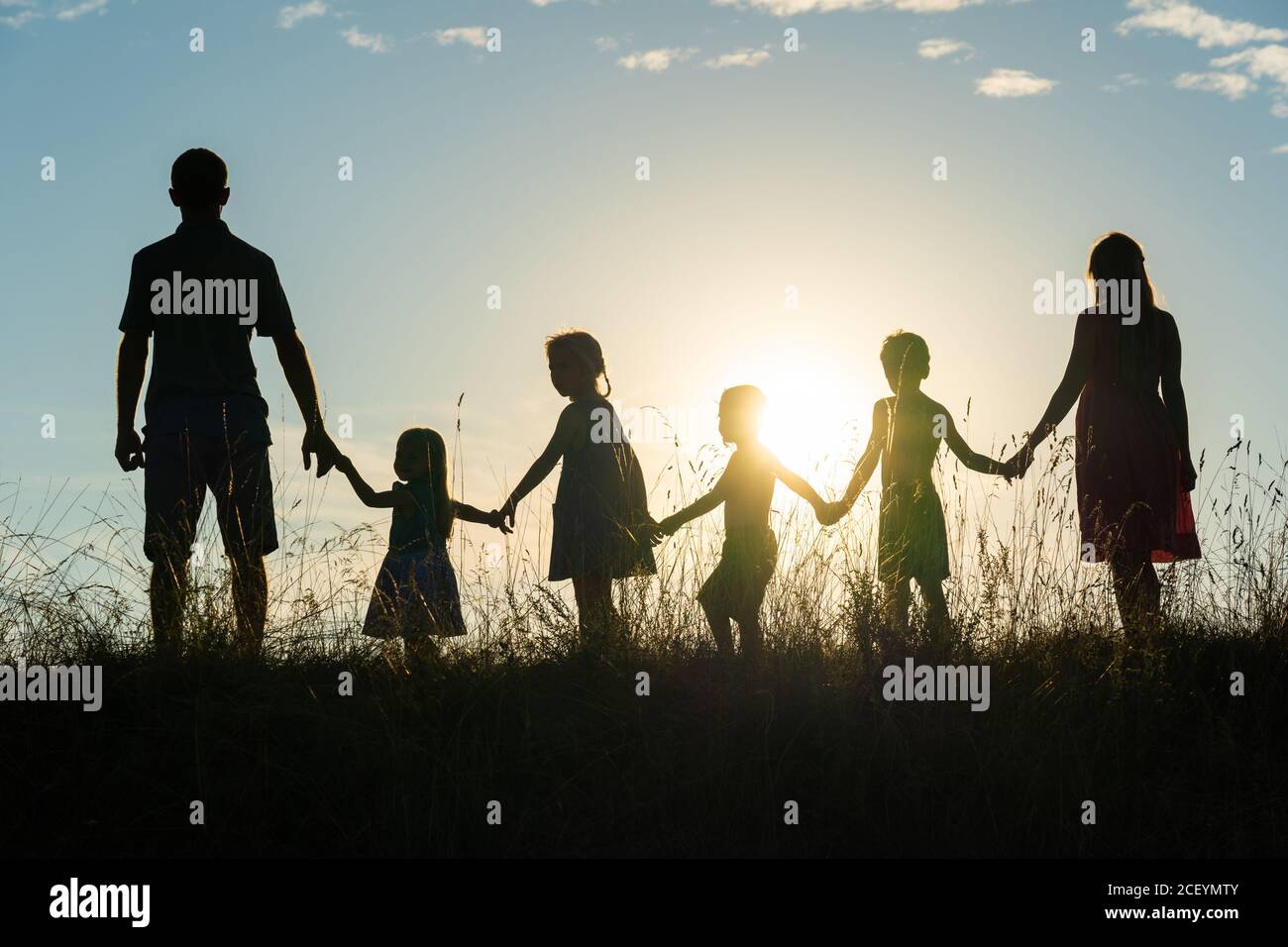 Silueta de una familia grande feliz al atardecer. Foto de stock