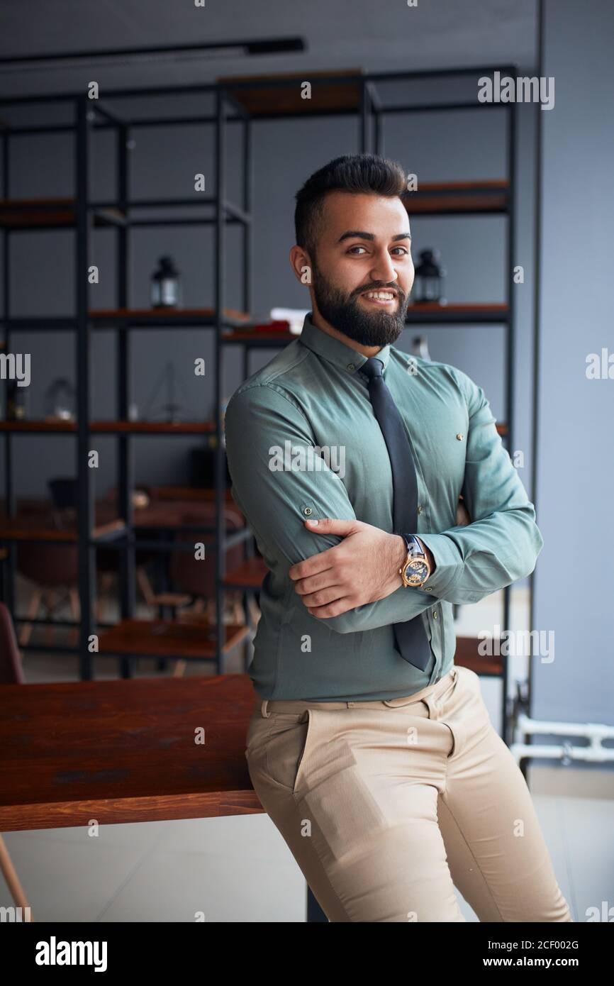 Significado busto violación Joven barbudo hermoso hombre de negocios del Oriente Medio de pie en la  oficina, mirando la cámara, líder de equipo de éxito con ropa formal,  posando para la foto Fotografía de stock -