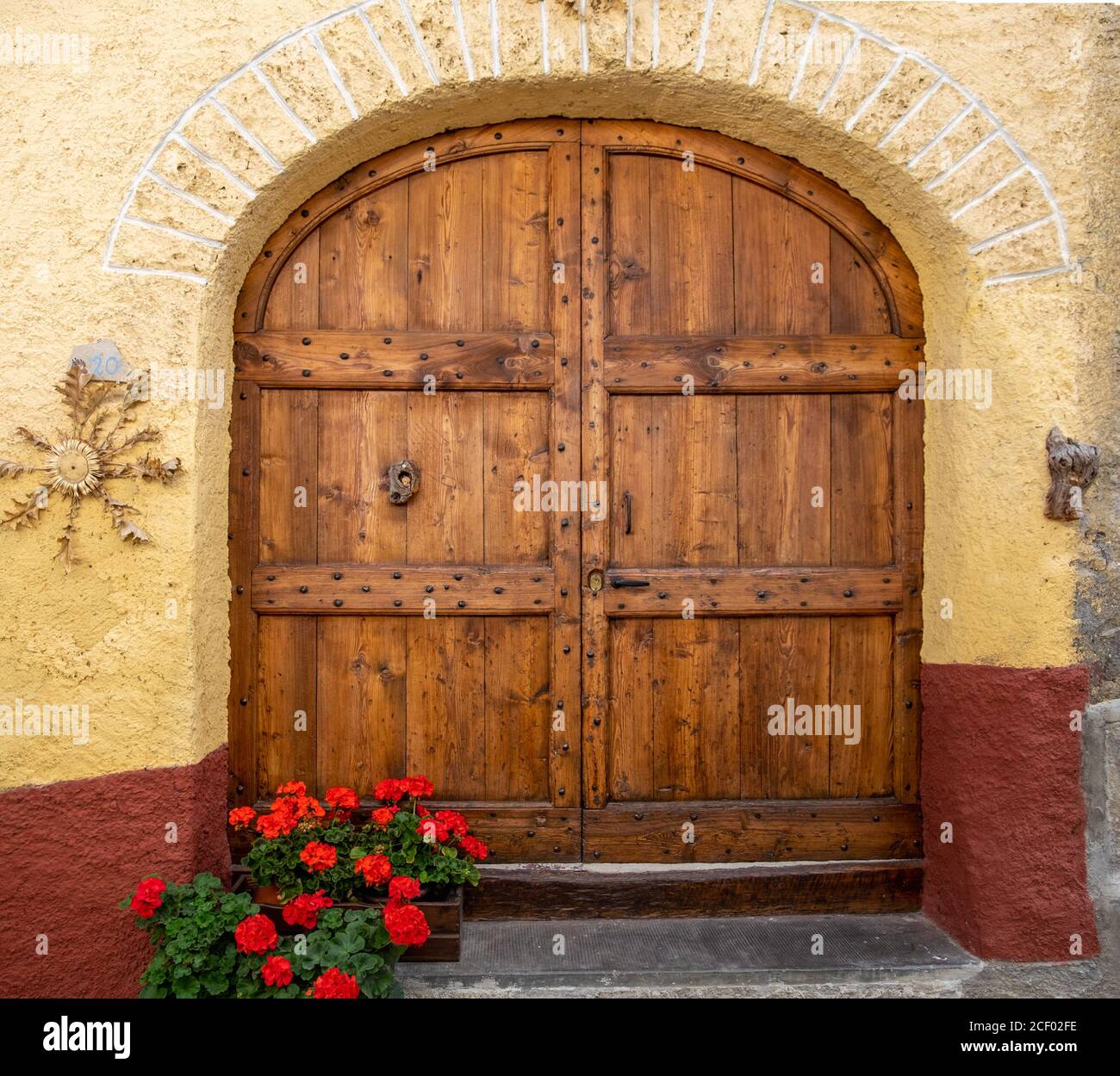 Antigua puerta doble tradicional de madera en el pequeño pueblo de Usseaux, Piemonte, Italia Foto de stock