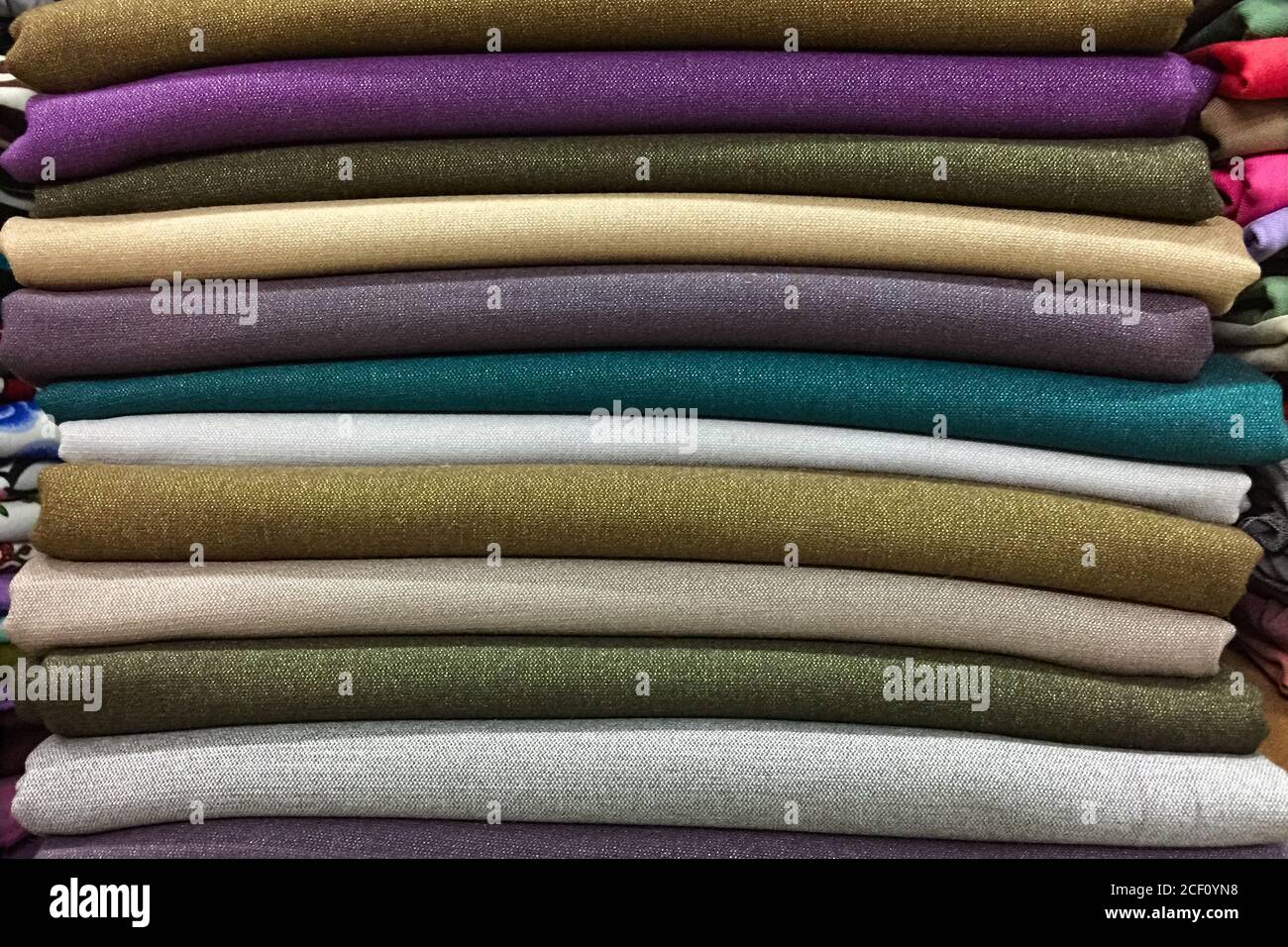 Tela de lino natural en diferentes colores doblada en un montón para la  venta en una tienda Fotografía de stock - Alamy