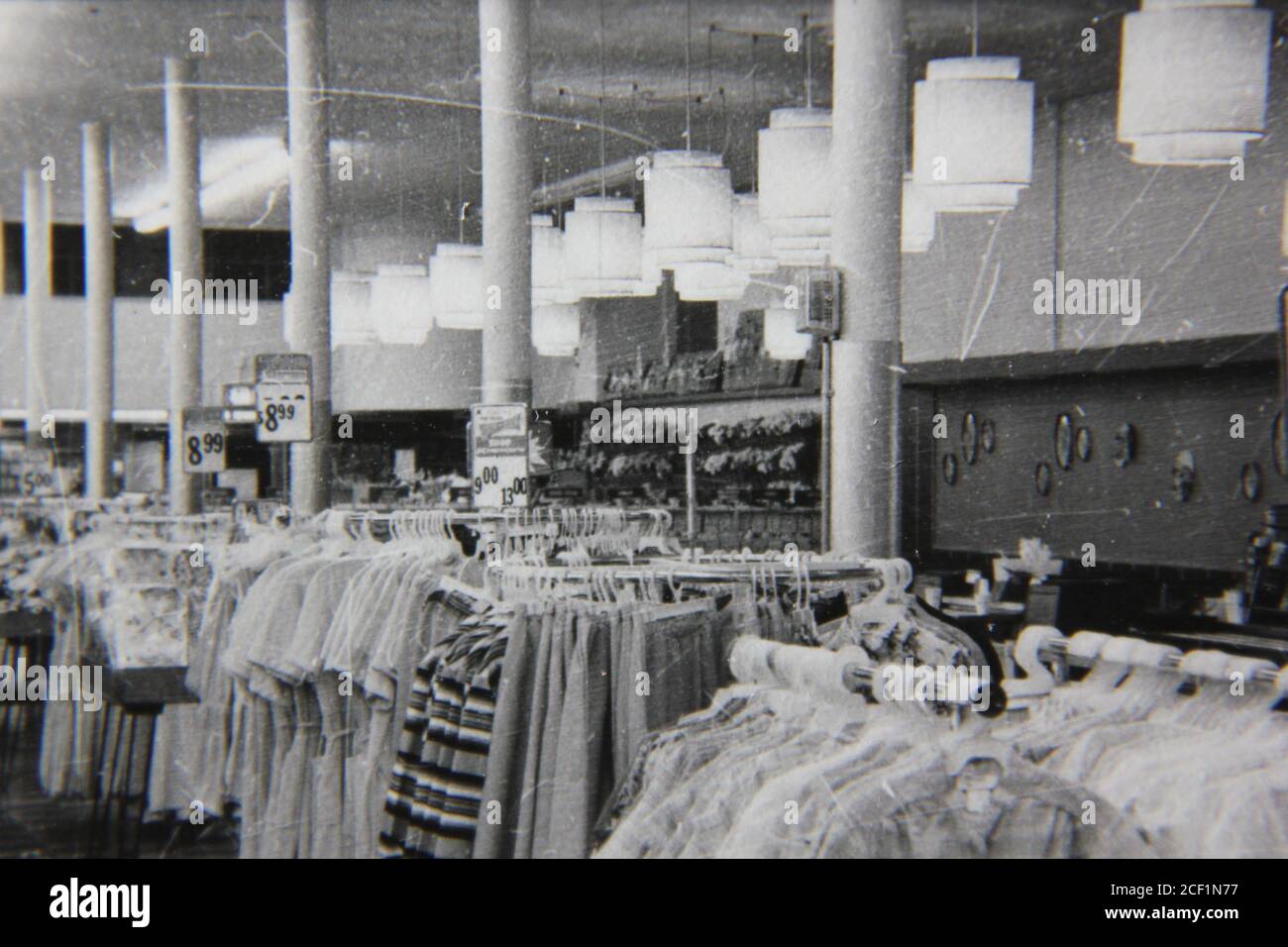 De alguna manera Rey Lear Hacer la cama Fotografía en blanco y negro de la época de los años 70 del interior de una  tienda regular llena de bastidores de ropa para la venta Fotografía de  stock - Alamy