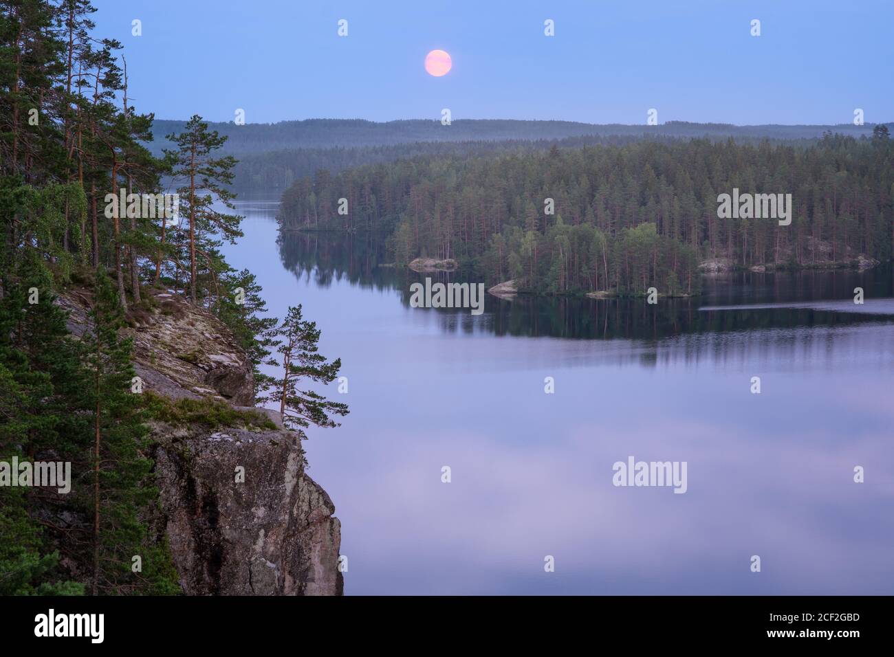 Paisaje a la luz de la luna con un bosque y un lago tranquilos en verano Noche en Finlandia Foto de stock
