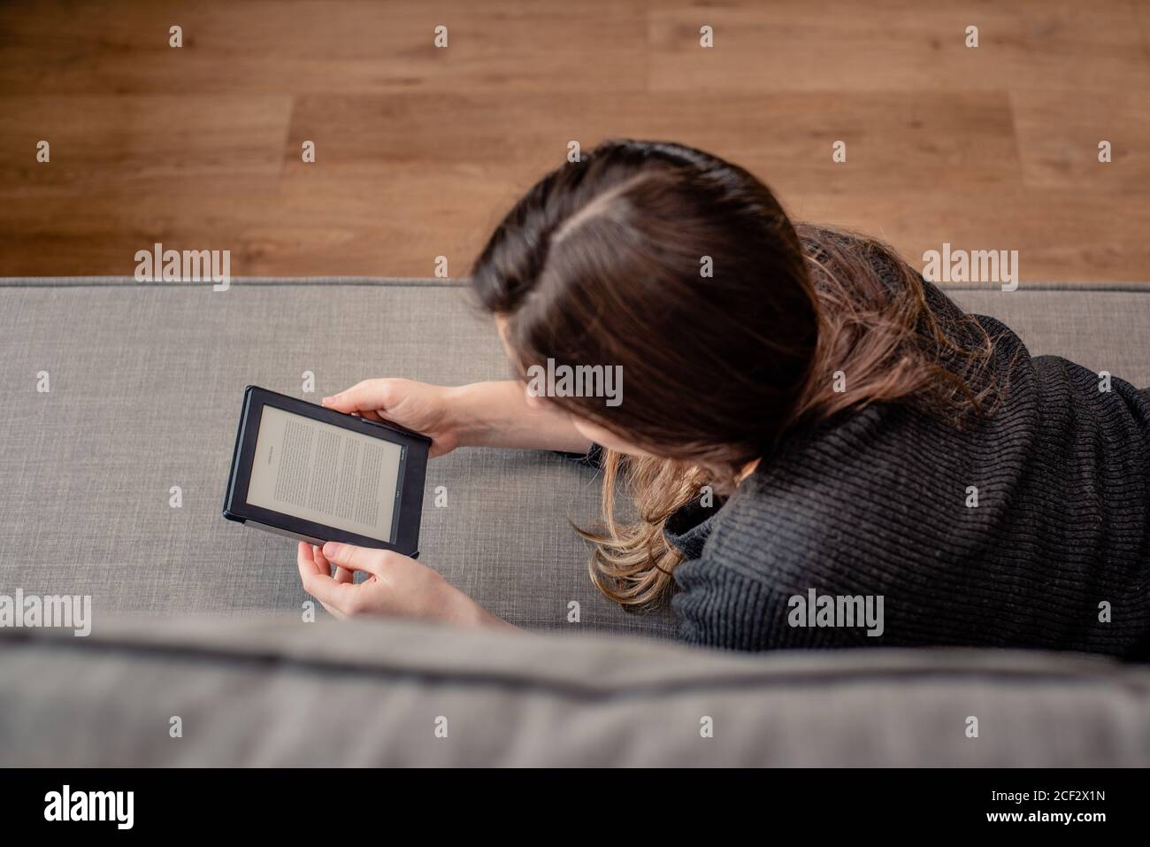 Mujer joven leyendo con lector electrónico Foto de stock